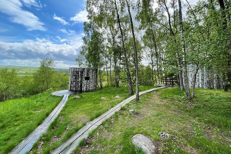 Bild på två av de arkitektritade vindskydden Birk och Birka på Lägerplats mellan Skymning och gryning på Hovdala Naturområde & Vandringscentrum 
